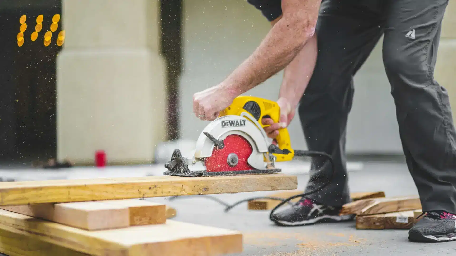 Construction worker using DeWalt Saw to cut 2x4.